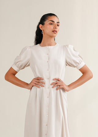 Puff Sleeve Midi Dress – WS25-182 for Women – Summer Reverie Collection | KOA | Shop Online.
Woman wearing a white dress with puffed sleeves against a plain background