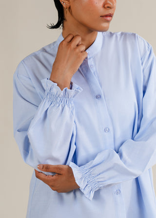 Ruffled Sleeve Shirt – WS25-187 for Women – Summer Reverie Collection | KOA | Shop Online.
Light blue shirt with smocked cuffs worn by a women against a neutral background