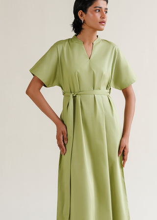 Belted V-Neck Dress – WS25-159 for Women – Summer Reverie Collection | KOA | Shop Online.
Woman wearing a light green dress with short sleeves on a plain background