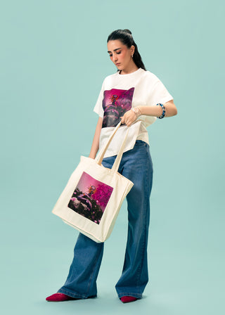 Tote Bag – Eden Reborn by Riza Qureshi – WS25-239 for Women – Art Board 01 Collection | KOA | Shop Online.
Woman holding a tote bag with a matching design against a light blue background