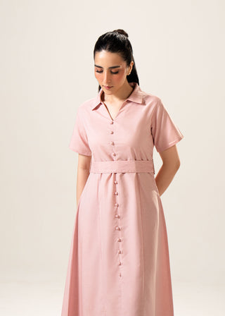 Linen Blend Dress with Panels – WS25-219 for Women – In-Transit Collection | KOA | Shop Online.
Woman wearing a pink dress with a belt against a plain background