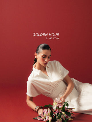 Woman in a white dress arranging flowers on a red background with 'Golden Hour Live Now' collection.