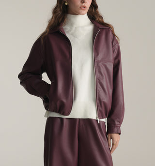 Women wearing a maroon KOA leather jacket and matching pants on a plain background